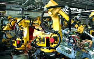 robot in azione mentre assemblano auto